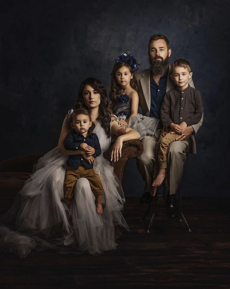 a family posing for a portrait in their wedding photo studio, with the child sitting on his mother's lap