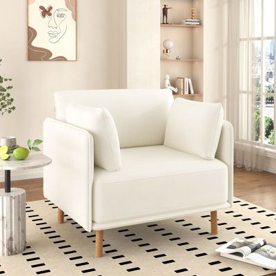 a white chair sitting on top of a black and white rug in a living room