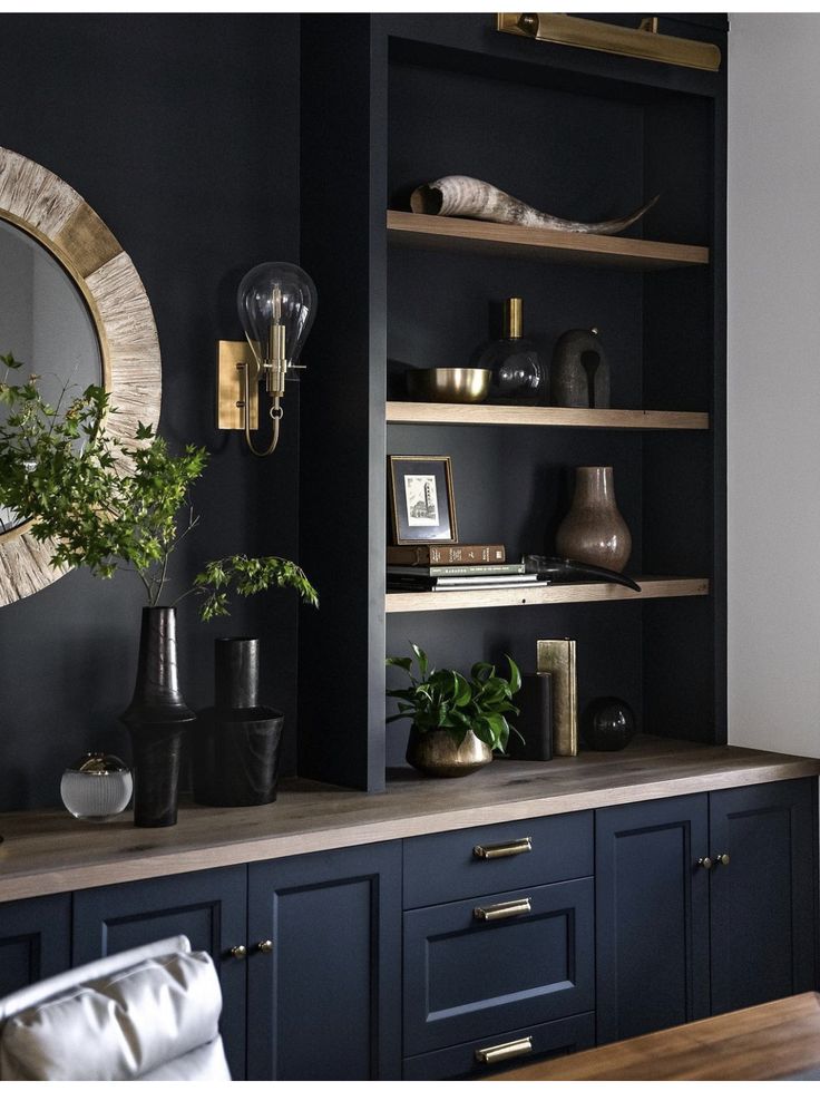 a living room with black walls and wooden shelves filled with vases, plants and other decorative items