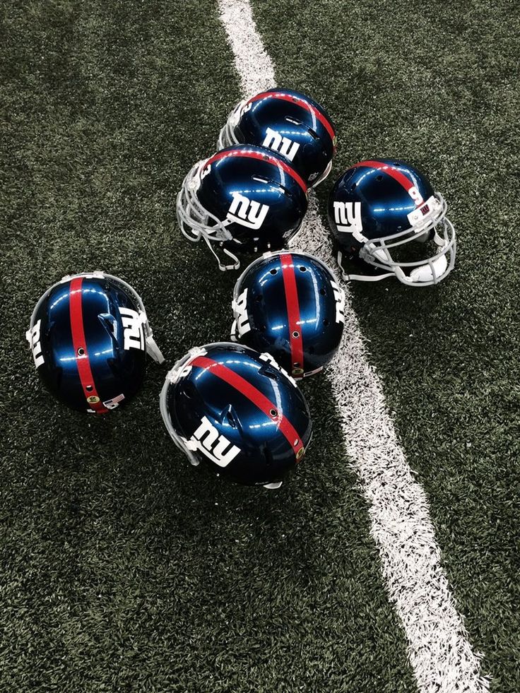 four football helmets laying on the field