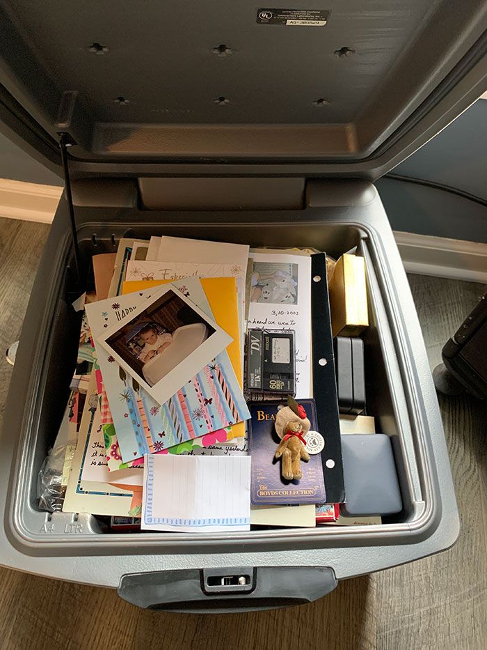 an open suitcase filled with lots of papers and other things on top of the floor