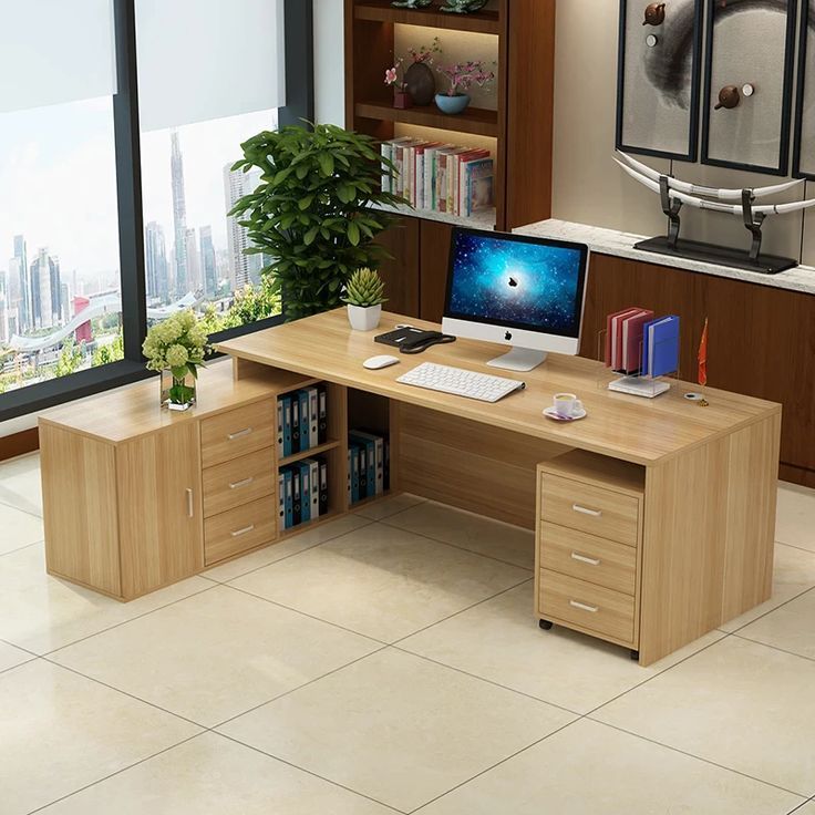 an office desk with a computer on it and bookshelves in front of the window