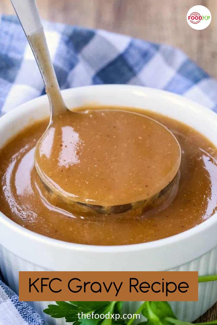 a spoon full of gravy sitting in a white bowl on top of a blue and white checkered cloth