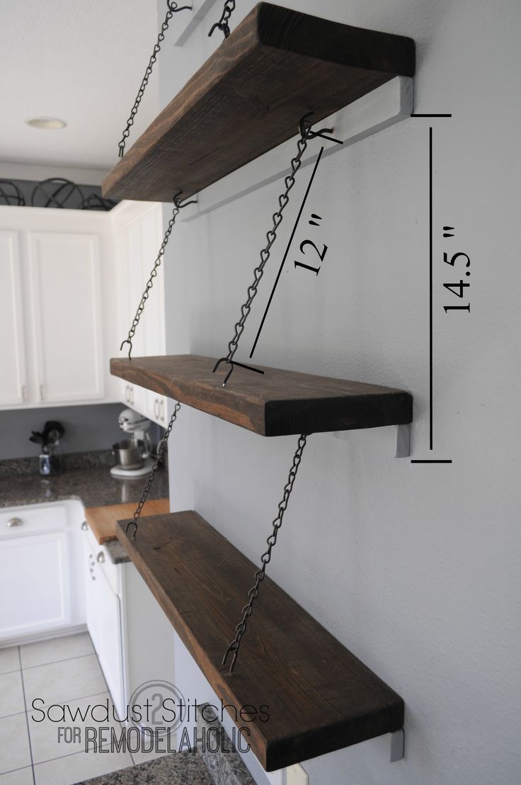 two wooden shelves with chains hanging from them in a kitchen next to a counter top