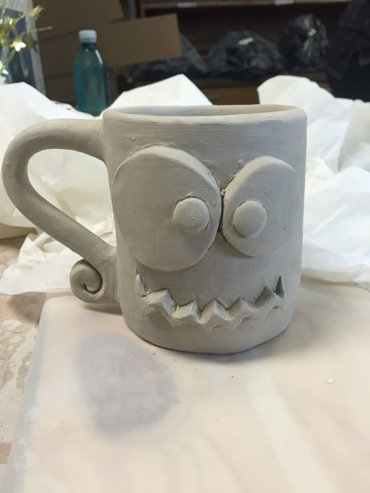 a ceramic mug that has been made to look like a monster's face on it