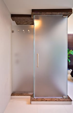 a bathroom with a glass shower door and white walls