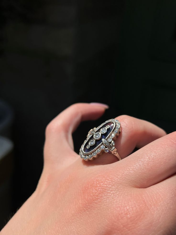 During the Victorian era, navette or “little ship” rings were highly en vogue, and were the perfect statement pieces for elegant nights out or celebrations. This rare Art Deco ring emulates the understated glamor of the navette design, creating a gorgeous and memorable silhouette! Crafted circa 1920’s in 18 carat white gold, this ring features a truly unique synthetic blue topaz gem with a smooth, flat cut. Just look at that hue! The dimensions of color in this topaz is remarkable, and there is Fine Jewelry Marquise For Evening, Art Deco Platinum Jewelry For Evening, Marquise White Gold Jewelry For Evening, White Gold Marquise Jewelry For Evening, Oval Jewelry With 17 Jewels For Evening, Oval Jewelry With Polished Finish For Evening, Evening Marquise Diamond White Jewelry, Luxury Marquise Jewelry With Diamond Accents, Art Deco Diamond Ring With Gemstone