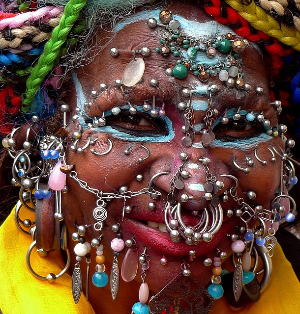 a close up of a person with jewelry on their face and eyes, wearing an elaborate headdress