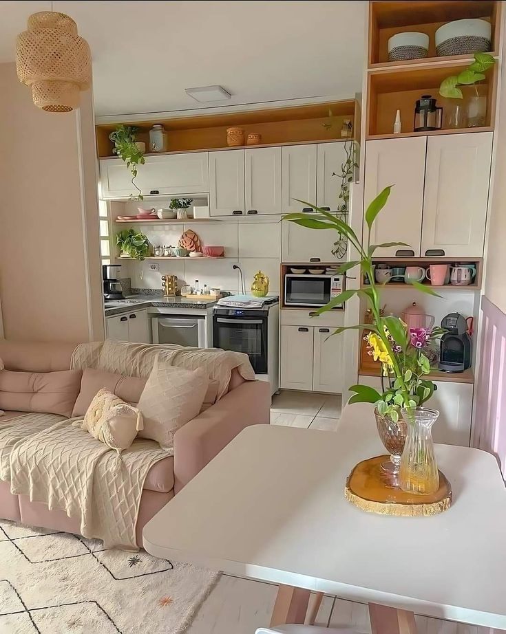 a living room filled with furniture next to a kitchen and dining room table in front of a stove top oven