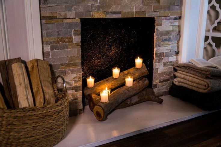 candles are lit in front of a fireplace