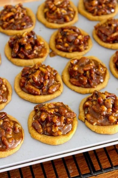 many cookies with nuts are on a cookie sheet