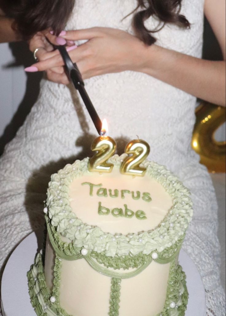 a woman cutting into a two - tiered cake with the number 22 on it