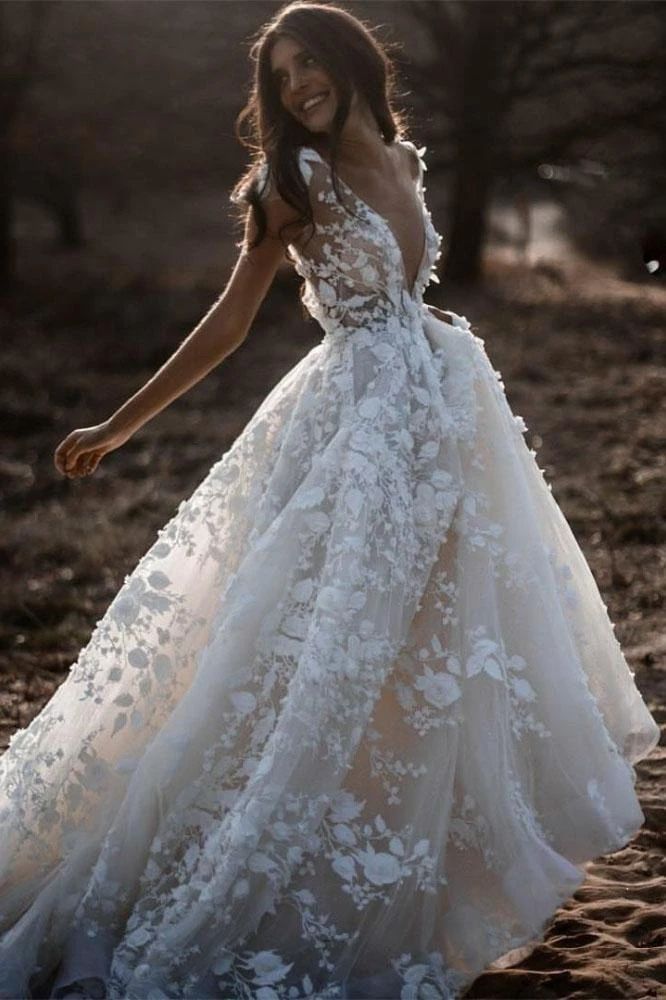 a woman in a white wedding dress is walking through the sand with her arms outstretched