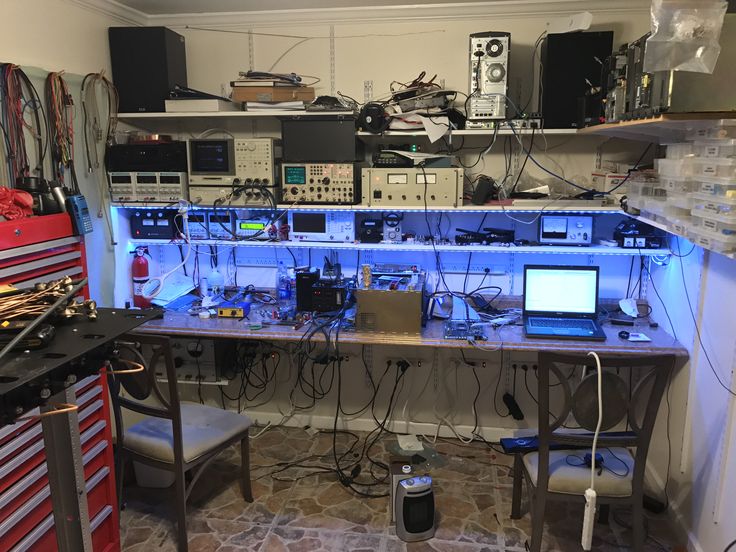 a room filled with electronic equipment and lots of wires on top of it's desk