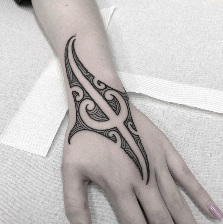 a woman's hand with a tattoo design on the middle of her left arm