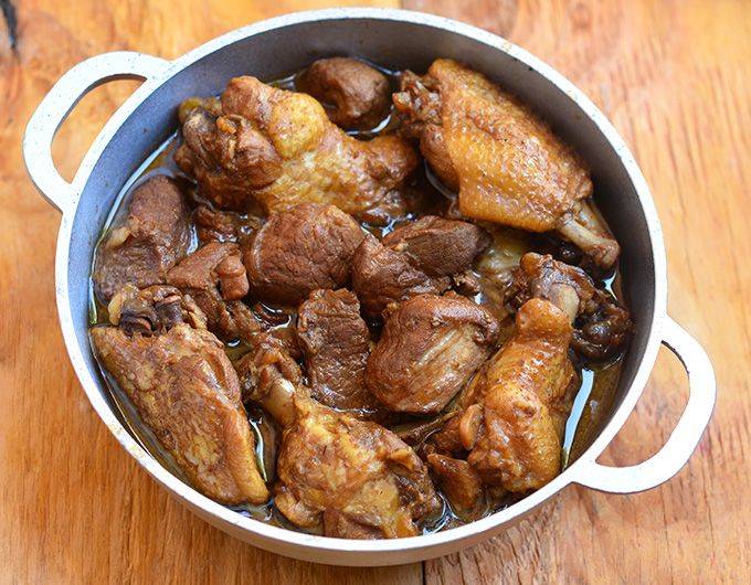 a pot filled with meat and vegetables on top of a wooden table