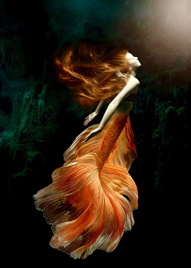 a woman is floating in the water with her hair blowing back and long, flowing dress