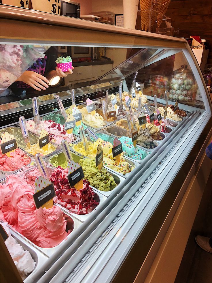 a display case filled with lots of different types of ice creams and desserts