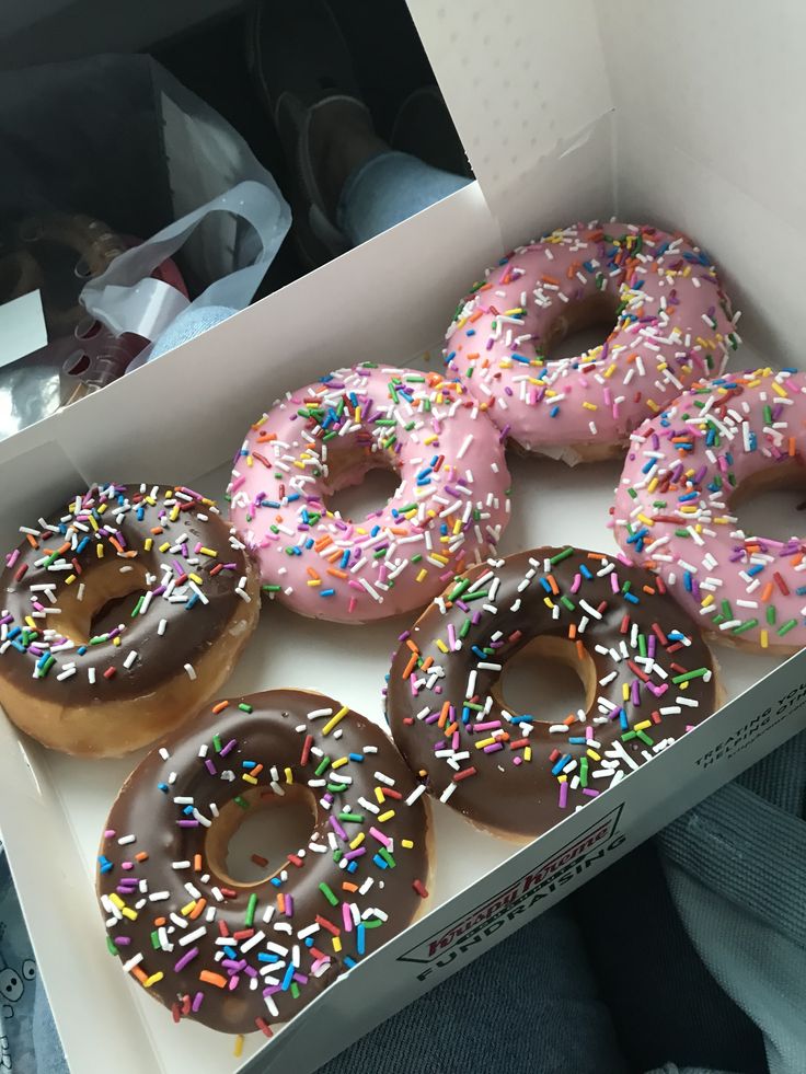 six donuts with chocolate frosting and sprinkles in a white box