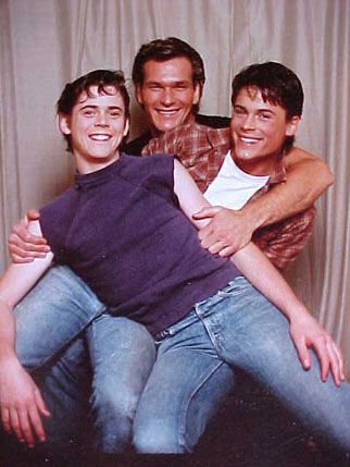 three young men are hugging each other in front of a curtain