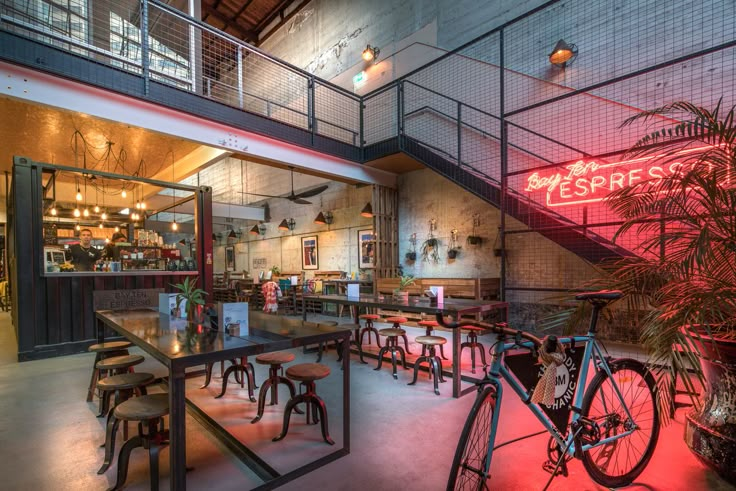 the interior of a restaurant with tables, chairs and bicycles on display in front of it