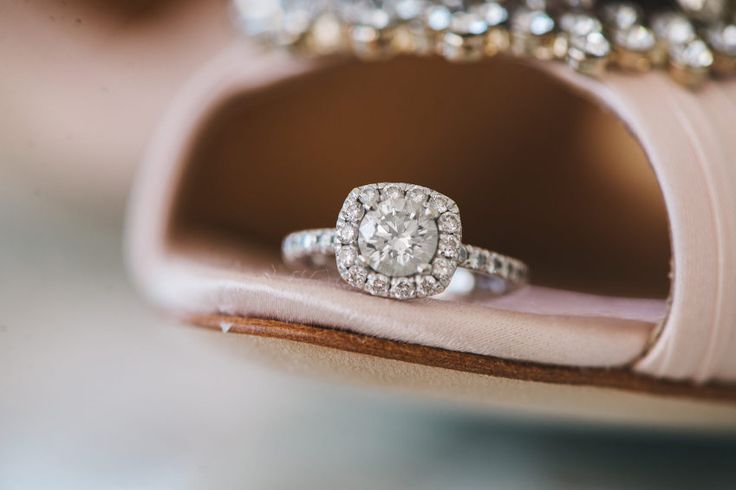 a diamond ring sitting on top of a pink shoe