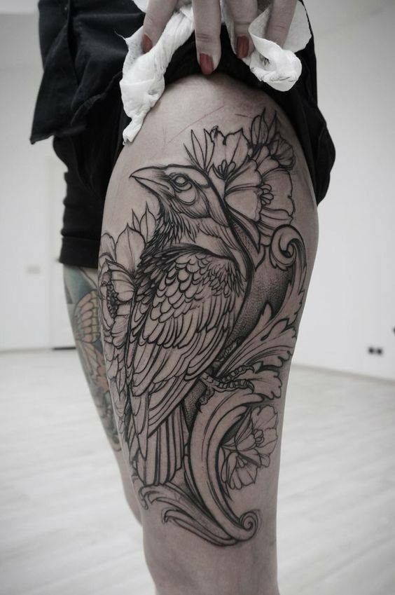 a woman's thigh with a bird tattoo on it