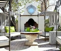 an outdoor patio with black and white striped awnings, green pillows and chairs