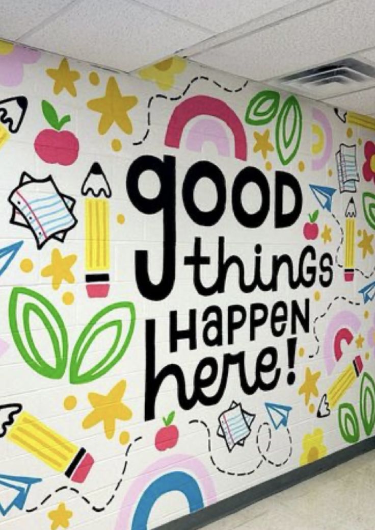 a colorful wall with the words good things happen here painted on it in an office cubicle