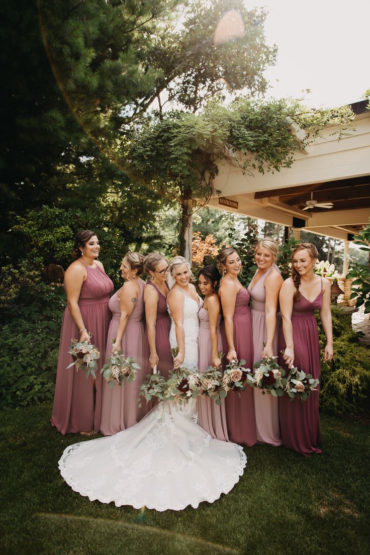 a group of women standing next to each other on top of a lush green field