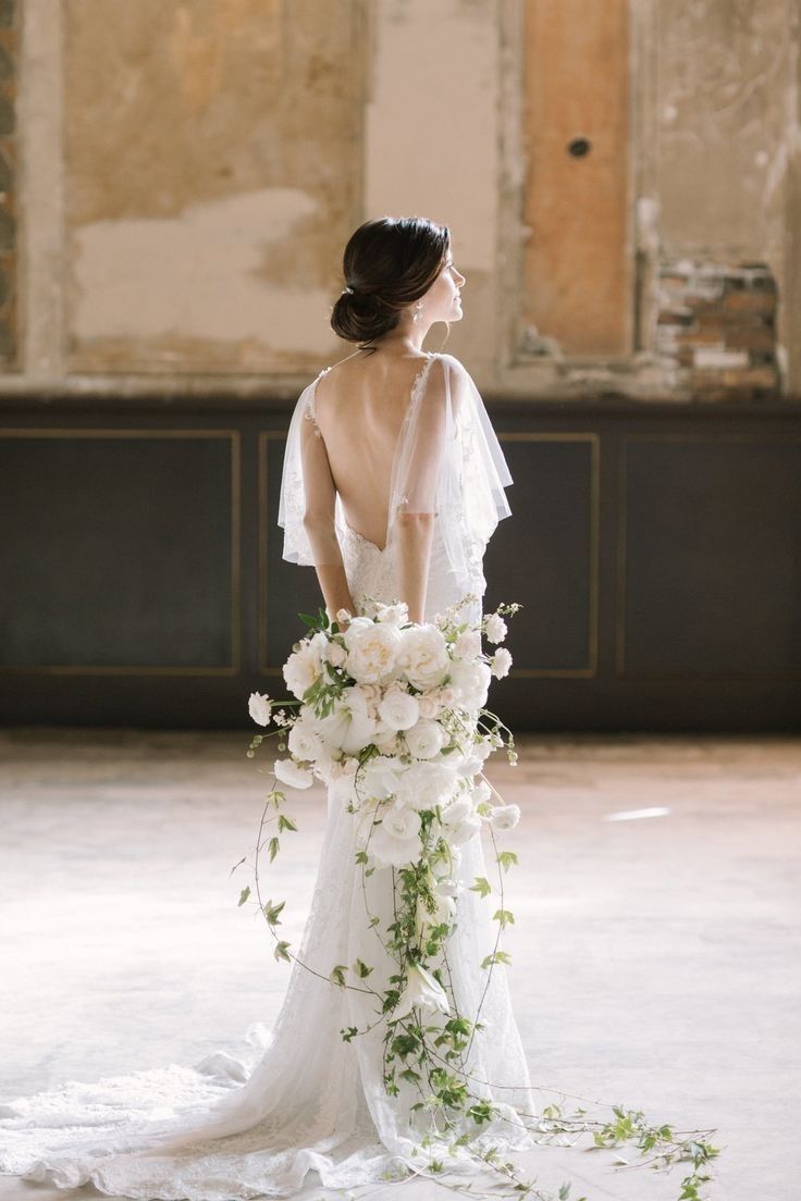 a woman in a wedding dress with flowers on the floor