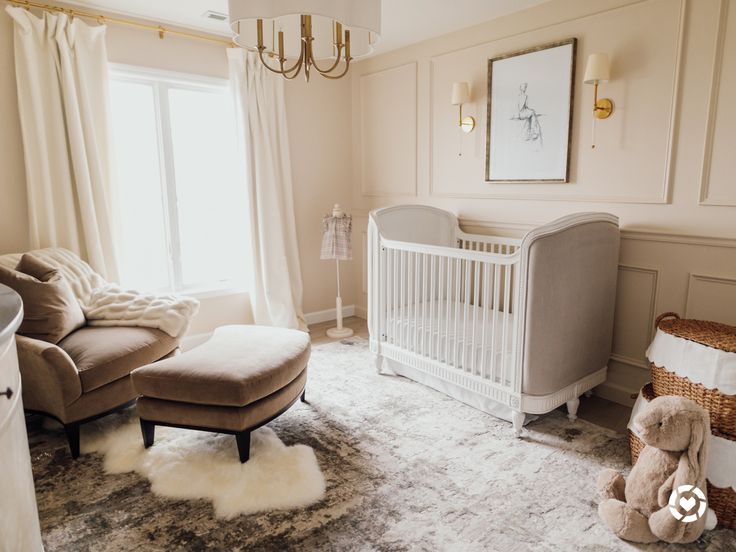 a baby's room with a couch, crib and chair in it is shown