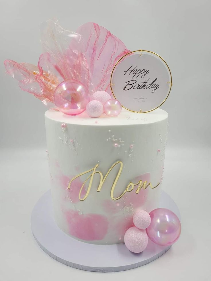 a birthday cake decorated with pink and gold decorations