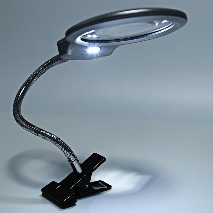 a magnifying glass is on top of a metal stand with a light coming from it