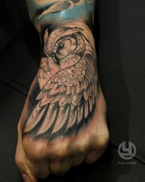 a person with a tattoo on their hand and an owl in the middle of his arm