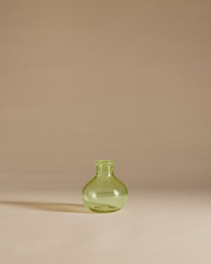 a small green vase sitting on top of a table