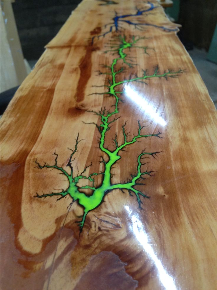 a long wooden table with green and blue designs on it