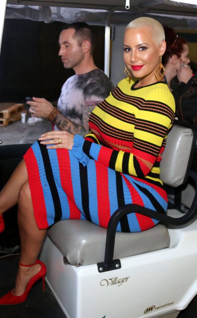 a woman sitting on the back of a white golf cart in front of other people