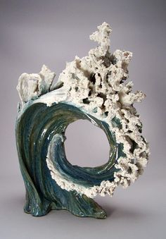 a ceramic sculpture that looks like an ocean wave with corals on the top and bottom