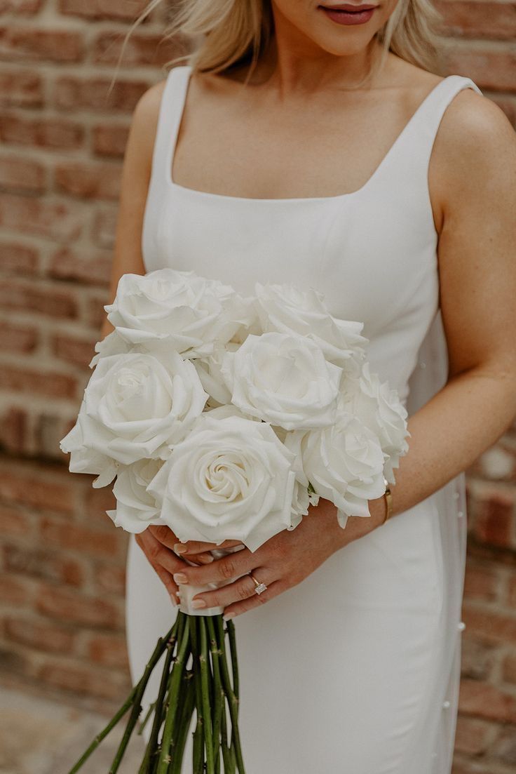 a woman holding a bouquet of white flowers