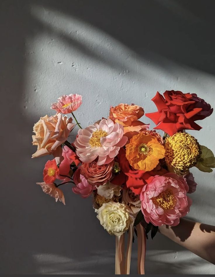 a vase filled with lots of different colored flowers