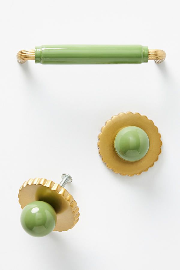 two green and gold knobs on white surface