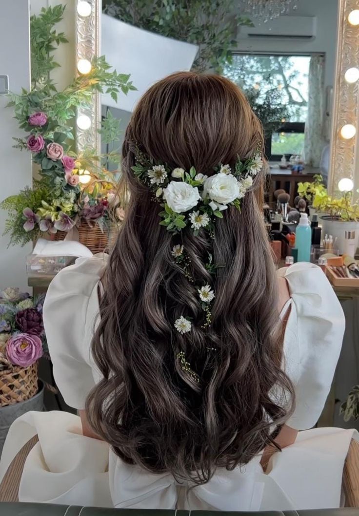 a woman sitting in front of a mirror with flowers on her head and hair comb