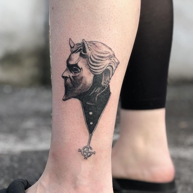 a woman's foot with a tattoo of a man in a suit and tie