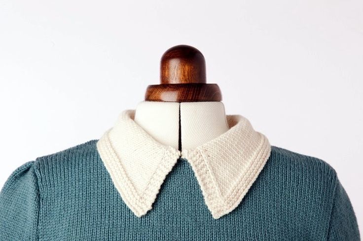 a green sweater with white collar on a mannequin