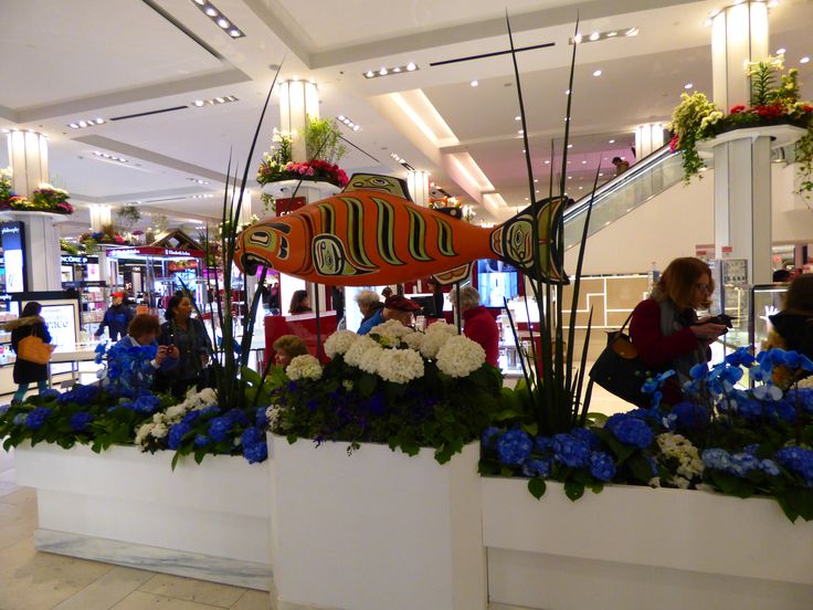 people are sitting at tables with flowers and fish decorations in the store's lobby