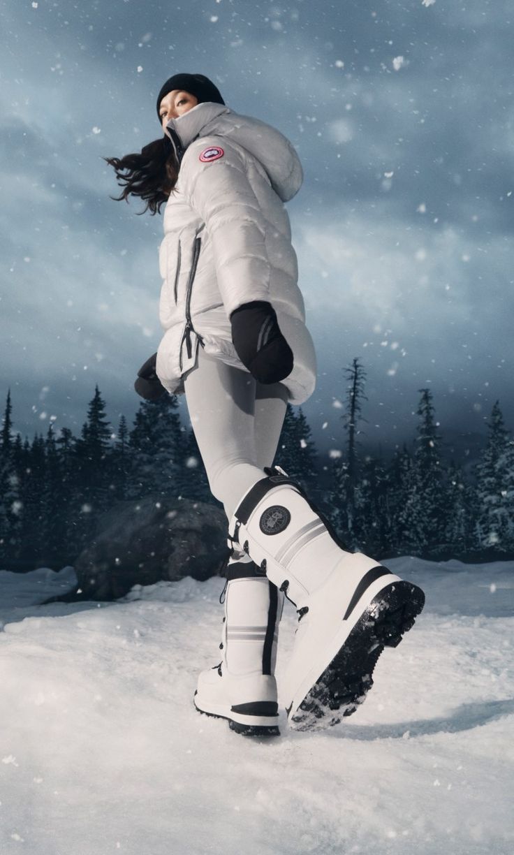 a woman in white jacket and boots on snow covered ground