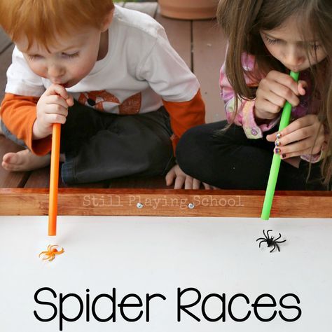 two young children are playing with toothbrushes in front of a spider race sign