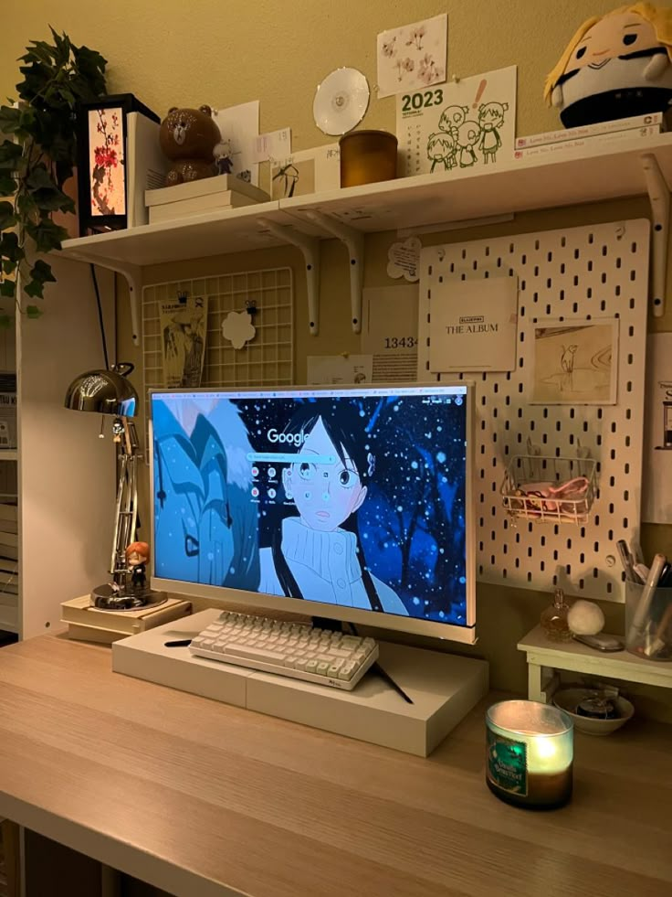 a desktop computer sitting on top of a wooden desk next to a lamp and potted plant