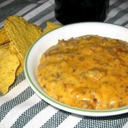 a white bowl filled with cheese and tortilla chips on top of a table